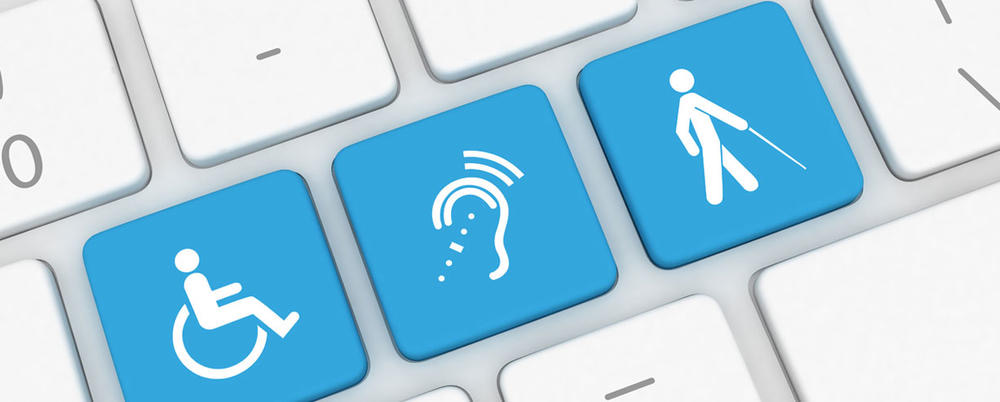 Keyboard keys printed with accessibility symbols for wheelchair access, hearing, and a person with a white cane